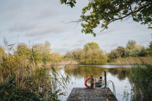 a boat is tied to a dock on a lake at RewildThings Treehouses in Gloucester
