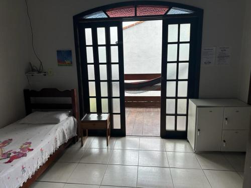 a bedroom with a bed and an open door at Hostel Bike Point Caraguatatuba in Caraguatatuba