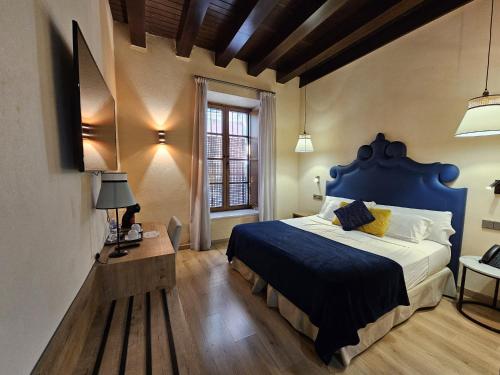 - une chambre avec un lit bleu et une fenêtre dans l'établissement Boutique Puerta Real, à Séville