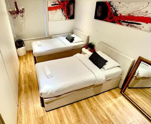 um quarto com duas camas e um espelho em Haymarket 2: Large Central Apt! em Londres