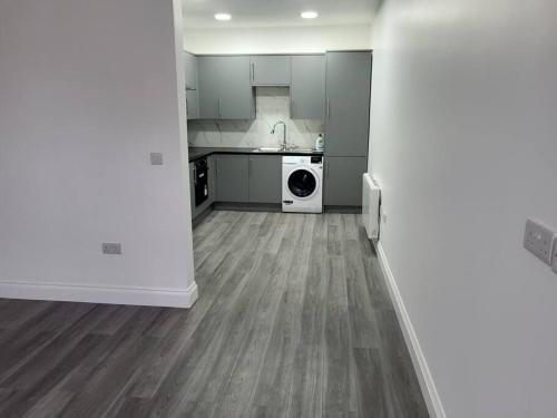 a kitchen with a washer and dryer in a room at NEW 1 BED FLAT IN DARTFORD- 40 Mins into London -SLEEPS 3-FIBRE BROADBAND-PARKING-10 MINS WALK TO CITY CENTRE in Kent