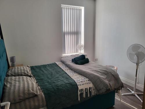 - une chambre avec un lit, un ventilateur et une fenêtre dans l'établissement NEW 1 BED FLAT IN DARTFORD- 40 Mins into London -SLEEPS 3-FIBRE BROADBAND-PARKING-10 MINS WALK TO CITY CENTRE, à Kent