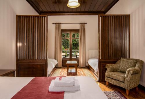 a bedroom with a bed and a chair and a window at Hotel Giamandes in Elati Trikalon