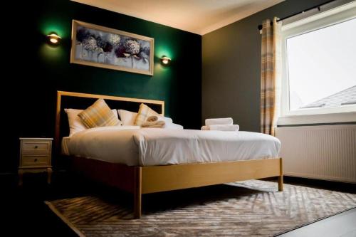 Un dormitorio con una cama con paredes verdes y una ventana en Lomond Park Hotel en Balloch