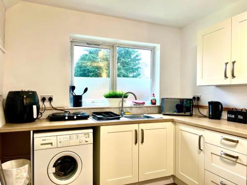 una cocina con fregadero y lavadora en The Annexe, St Andrews house hotel, Two bedrooms Sleeps 4, en Preston