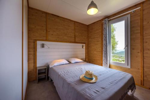 a bedroom with a bed with a hat on it at Camping U Pirellu in Porto-Vecchio