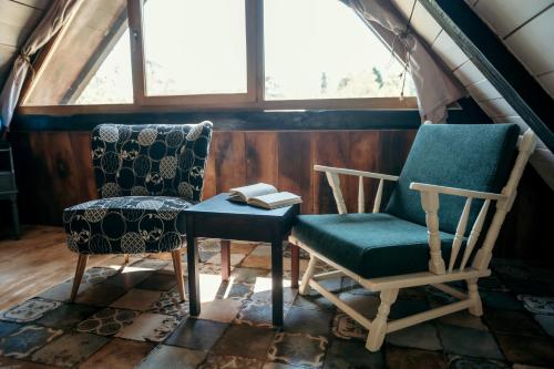 two chairs and a table in a room with a window at Magaze de Luxe in Gradačac