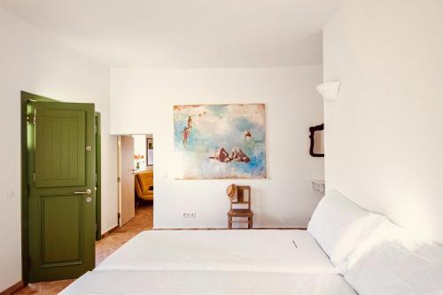 1 dormitorio con 1 cama y una pintura en la pared en Casa Dona Antonia, en São Bartolomeu de Messines