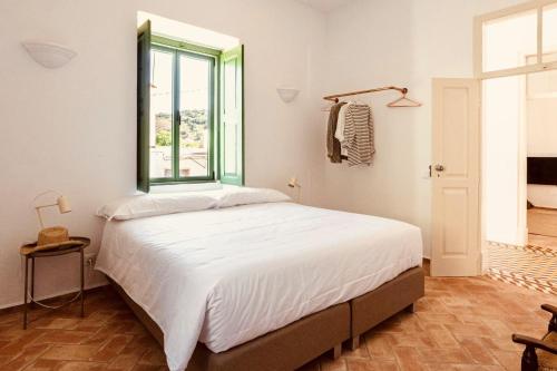 a bedroom with a large bed with a window at Casa Dona Antonia in São Bartolomeu de Messines