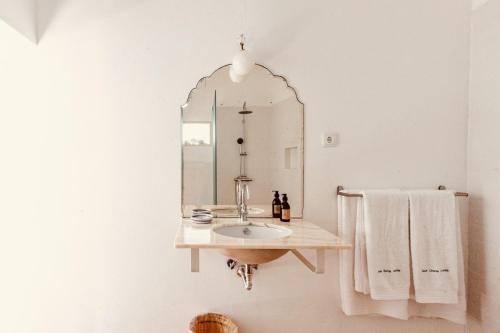 y baño con lavabo y espejo. en Casa Dona Antonia, en São Bartolomeu de Messines