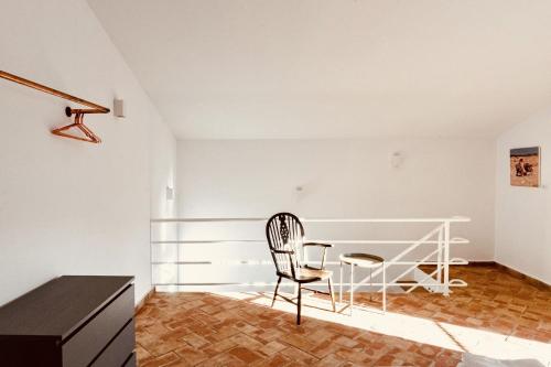 a white room with a chair and a desk at Casa Dona Antonia in São Bartolomeu de Messines