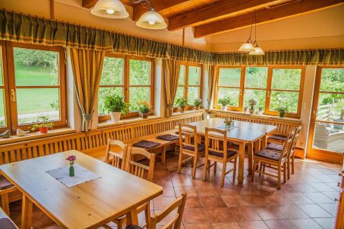 een eetkamer met tafels, stoelen en ramen bij Weingut Albrecher vlg. Sraka in Leutschach