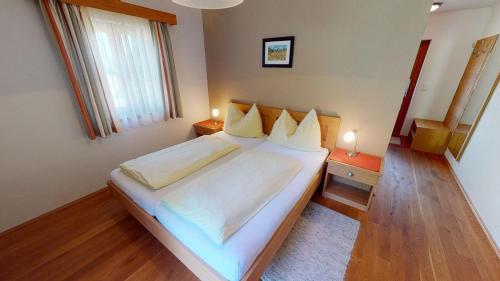 1 dormitorio con 1 cama grande con sábanas y almohadas blancas en Weingut Albrecher vlg. Sraka, en Leutschach