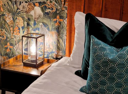 a bed with a table with a lantern on it at The Academy House by Bevolve in Shrewsbury
