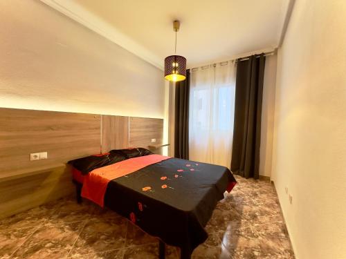 ein Schlafzimmer mit einem Bett in einem Zimmer mit einem Fenster in der Unterkunft Modern Apartment On Playa Del Cura in Torrevieja