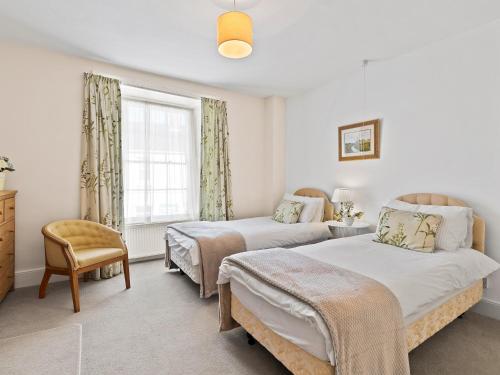 a bedroom with two beds and a window at New Cross House in St. Davids