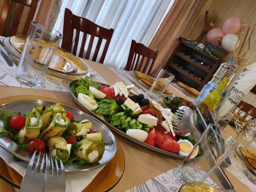 a table with two plates of food on top at Hotel Perfect in Yamna