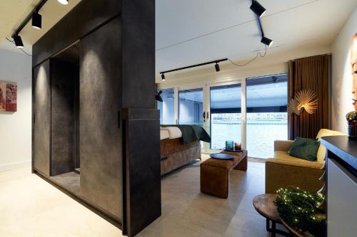 a room with a bed and a living room with a couch at Nomad Water Studio in Harderwijk