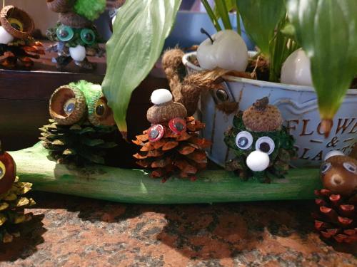 an arrangement of owls and pine cones on a plant at Hotel Perfect in Yamna