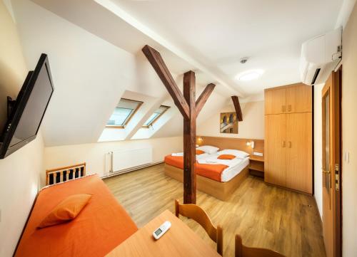 プラハにあるホテル ゴールデン シティ ガルニの屋根裏のベッドルーム(ベッド1台、ダイニングテーブル付)