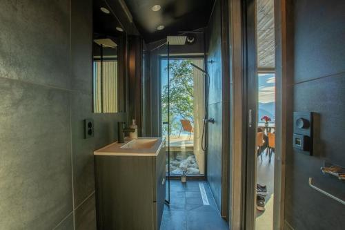a bathroom with a sink and a shower with a window at Sørheim FjordPanorama in Skjolden