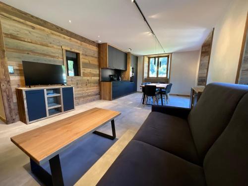 a living room with a couch and a table at Gite Roche Des Ducs avec Piscine toute l'année, Spa, Sauna, Hammam in Rochesson