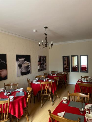 a dining room with tables and chairs with red table cloth at The Durham hotel in Seaton Carew