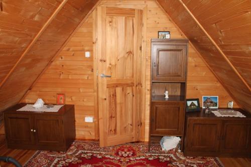 Pokój z drewnianą kabiną z drewnianymi drzwiami w obiekcie Domek Aleksandra w mieście Zbychowo