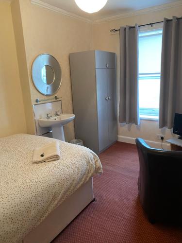 a bedroom with a bed and a sink and a mirror at The Durham hotel in Seaton Carew