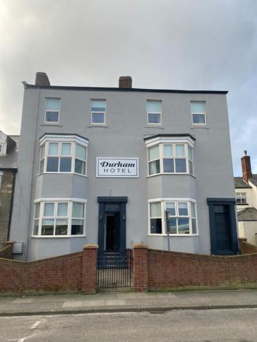a white building with a sign on it at The Durham hotel in Seaton Carew