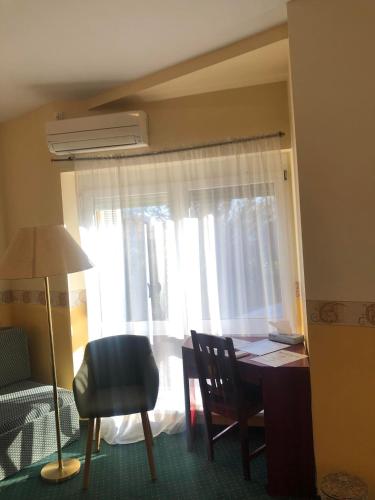 a room with a desk and a chair and a window at Kenguru Panzió és Csárda in Hódmezővásárhely