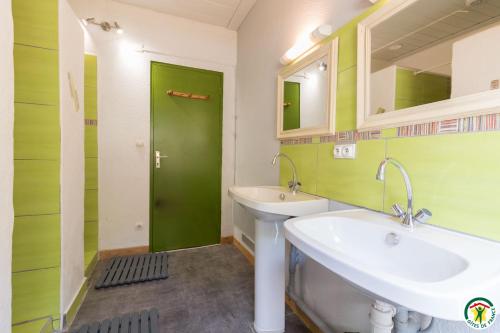 a bathroom with a sink and a green door at Auberge La Soulan in Boutx