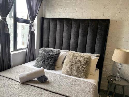 a bedroom with a bed with a black headboard and pillows at The Ark in Maboneng in Johannesburg