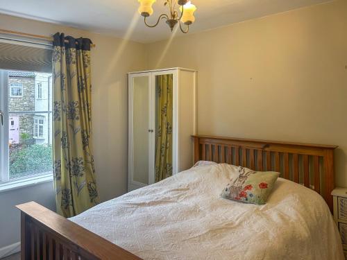 een slaapkamer met een bed met een kussen erop bij Hillview Cottage in North Nibley