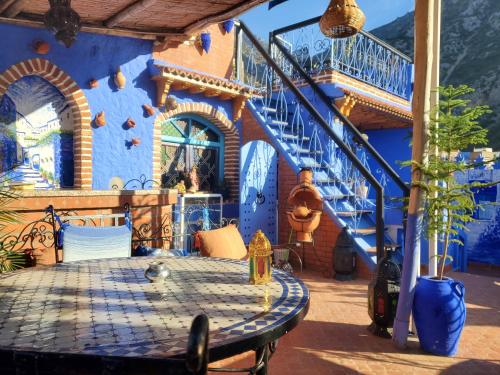 a blue house with a table and stairs at Blue city Chefchaouen in Chefchaouen