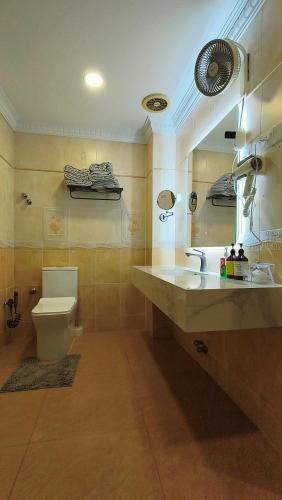 a bathroom with a toilet and a sink and a mirror at Kajang Pool Party Villa in Kajang