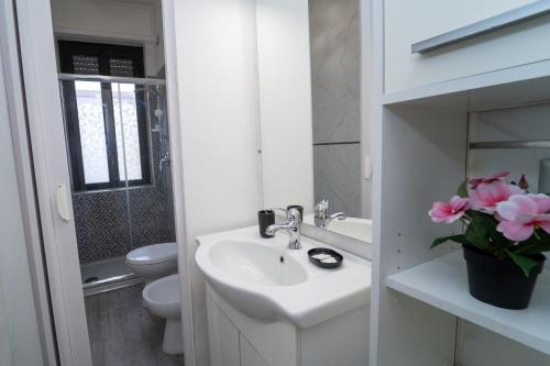 Baño blanco con lavabo y aseo en Appartamento 2 vicino Milano, en Bresso