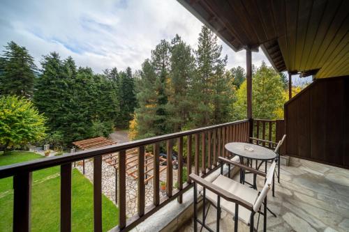 a balcony with a table and chairs and trees at Hotel Giamandes in Elati Trikalon
