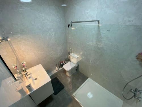 a bathroom with a toilet and a sink and a shower at Lovely 1-bedroom in St Julians in St Julian's