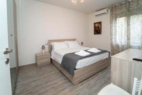a white bedroom with a bed and a bathroom at ALBA APARTMENT near MILAN in Bresso