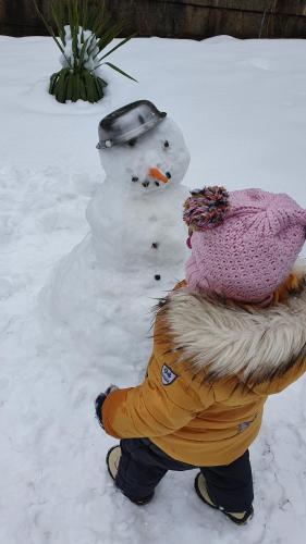 a snow man is standing next to a snowman at Hotel Perfect in Yamna