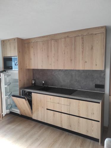 een keuken met houten kasten, een wastafel en een fornuis bij Appartamento Guido Pina in Livigno