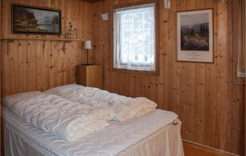 a bedroom with a large bed in a wooden wall at Cozy Home In Noresund With Kitchen in Noresund