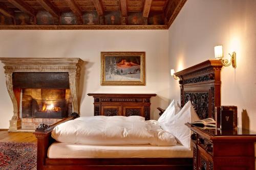 a bedroom with a bed and a fireplace at Hotel Schloss Mittersill in Mittersill