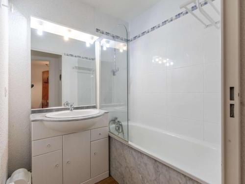 La salle de bains blanche est pourvue d'un lavabo et d'une douche. dans l'établissement Appartement La Mongie, 3 pièces, 7 personnes - FR-1-404-197, à La Mongie