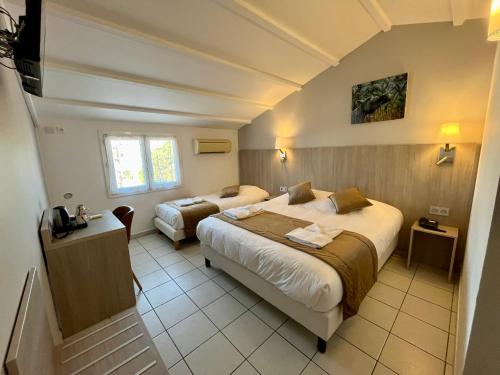 Ένα ή περισσότερα κρεβάτια σε δωμάτιο στο Hôtel Les Arcades