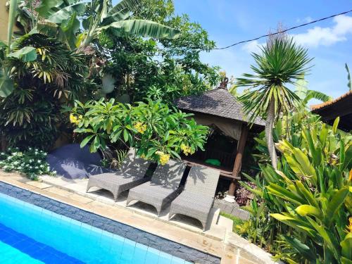 a resort with a swimming pool and some plants at Villa Layang Bulan - Male Only in Denpasar