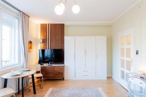 a living room with a large white cabinet and a table at Újbuda Rest Apartment With Air Condition and Balcony in Budapest