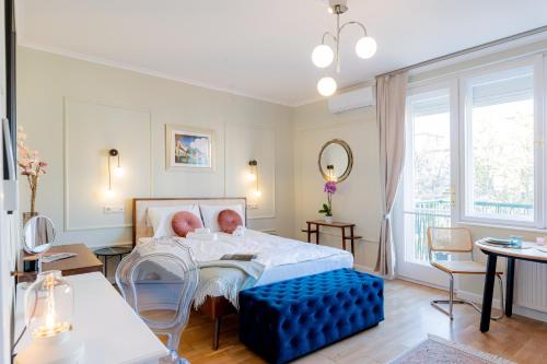 a bedroom with a bed and a blue ottoman at Újbuda Rest Apartment With Air Condition and Balcony in Budapest