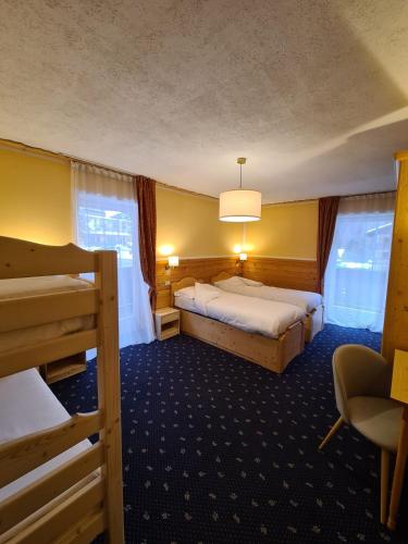 Una cama o camas en una habitación de Hotel Rododendro Val di Fassa